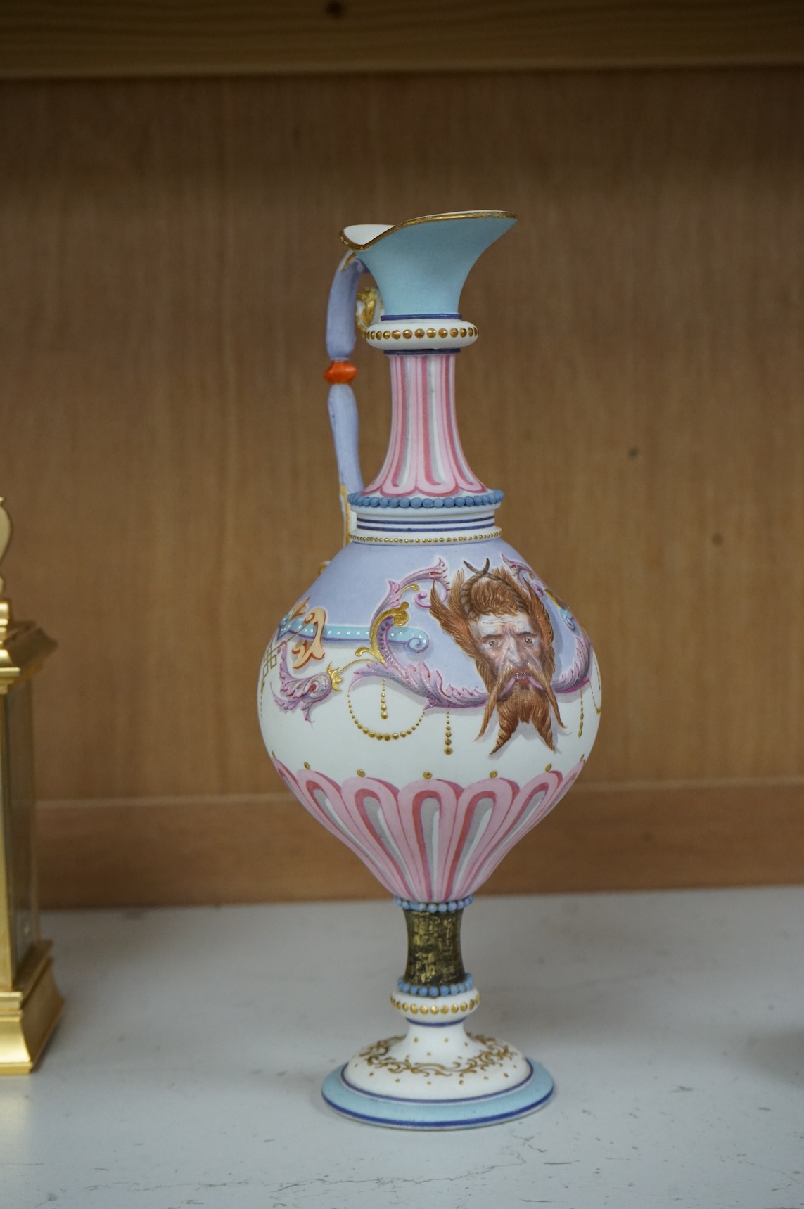 A 19th century Paris porcelain neo-classical pedestal ewer decorated with satyr mask and scrolls, 24cm high